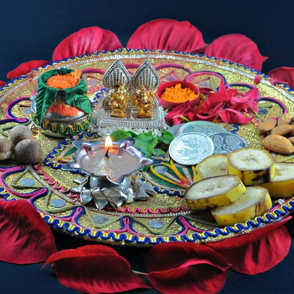 A colourful pooja thali adorned with miniature idols and a single diya is one of the popular Diwali pooja thali decoration ideas.
